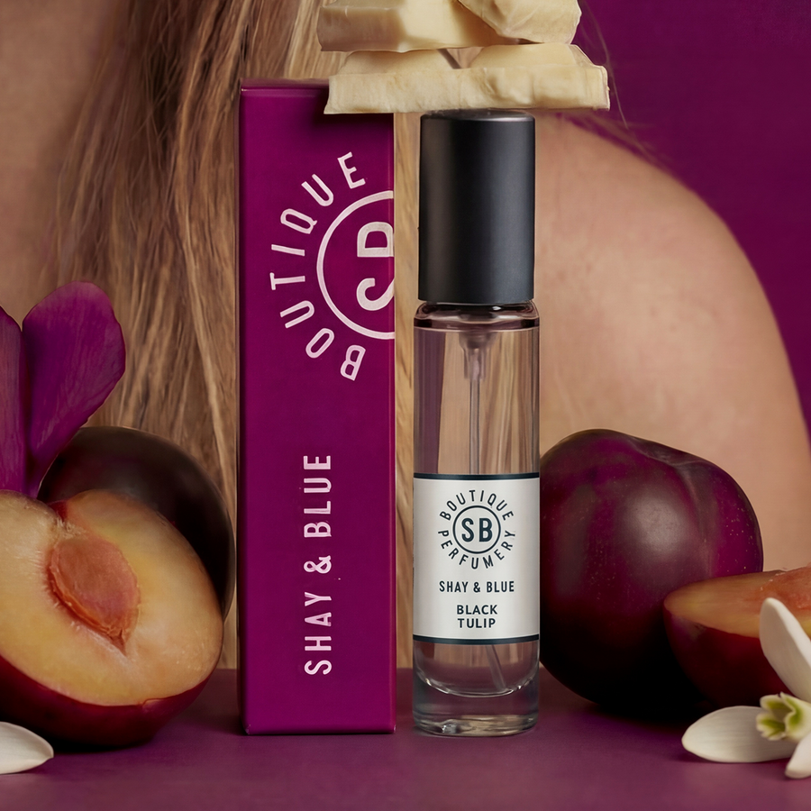 Shay & Blue perfume bottle with packaging and plums on a purple background