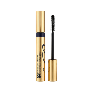 A gold tube of eyelash serum with its cap removed, showing the black applicator wand with bristles, on a light gray background. The text on the tube reads 'Surprisingly Extreme' and 'Lash & Eyelash Conditioner'.