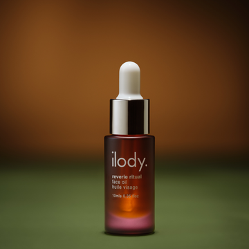 Ilody face oil dropper bottle on a gradient background