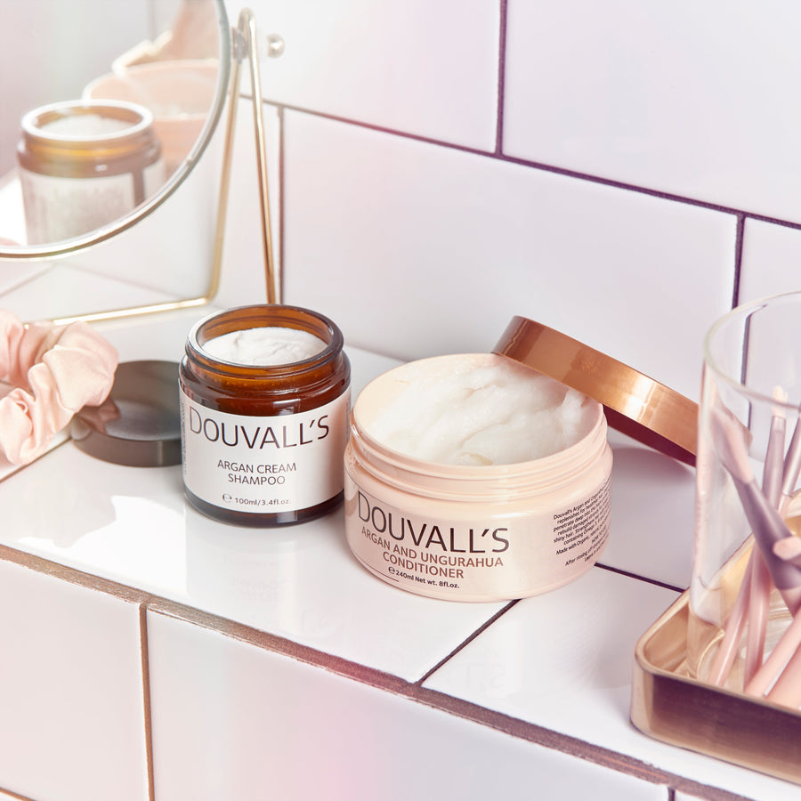 Douvall's hair care products on a bathroom counter with a mirror in the background.