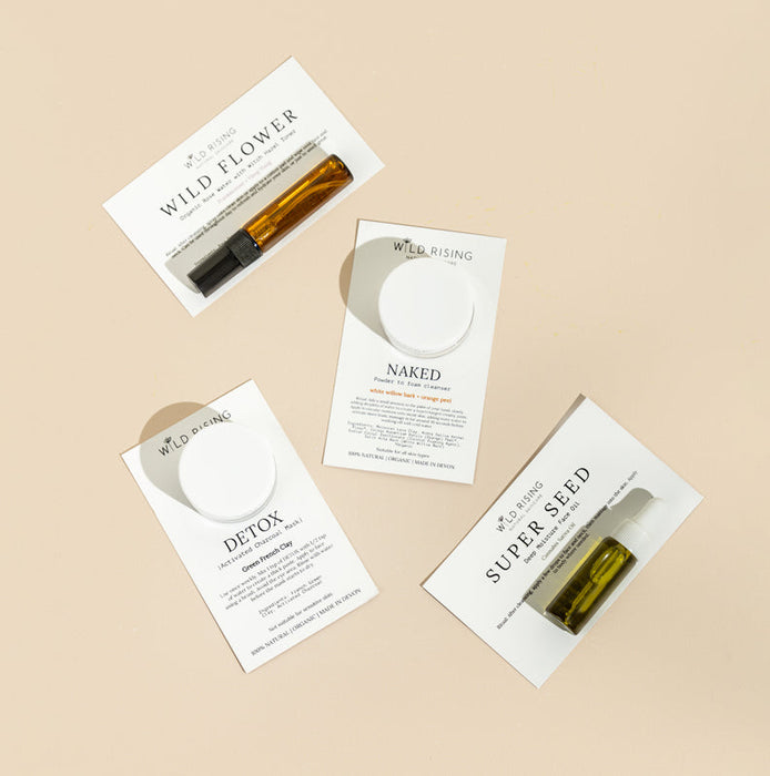 Four Wild Flower skincare products with their packaging on a beige background