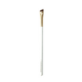 Eyebrow brush with gold ferrule and white handle on a green background.