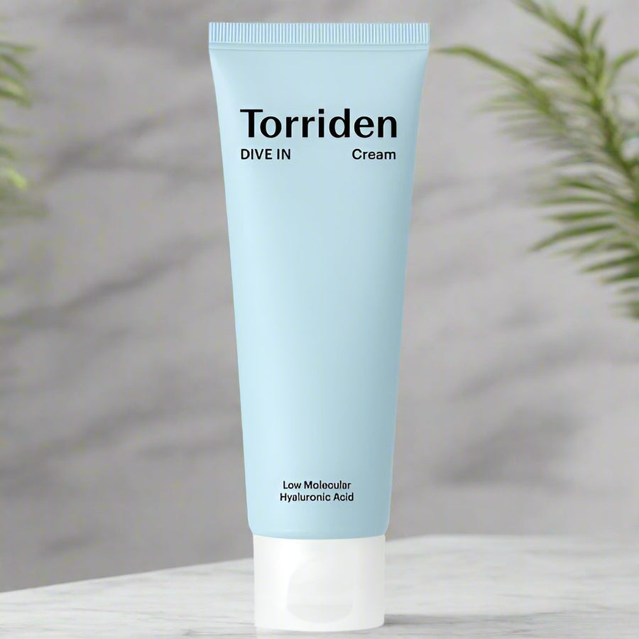 Torriden cream tube on a neutral background with plants